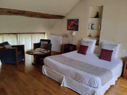 une chambre avec un grand lit blanc et une table dans l'établissement Le clos de fougères Les Fleuriéres, à Montoillot