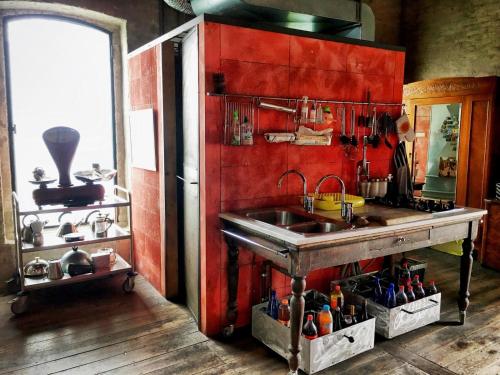 a kitchen with a sink and a red wall at loft dell'artista in Bocchere