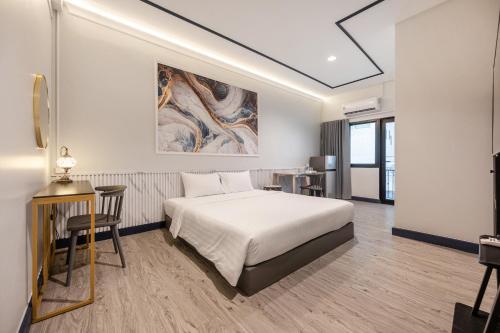 Una habitación de hotel con una cama, una mesa y un escritorio. en Capitel Rama 4, en Bangkok