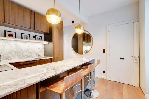 - une cuisine avec un comptoir en marbre et un miroir dans l'établissement Pick A Flat's Apartment in Montorgueil - Rue Saint Joseph, à Paris