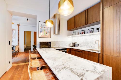- une cuisine avec un comptoir en marbre et des placards en bois dans l'établissement Pick A Flat's Apartment in Montorgueil - Rue Saint Joseph, à Paris