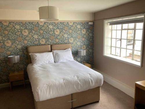 a bedroom with a large bed with floral wallpaper at The Market House in Glastonbury