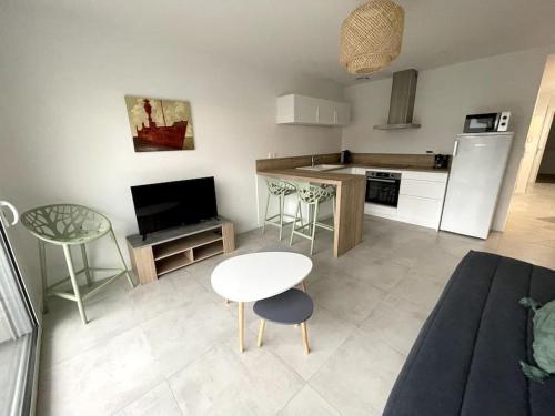 un salon avec une table et une cuisine dans l'établissement À proximité immédiate de la mer 2, à Dunkerque