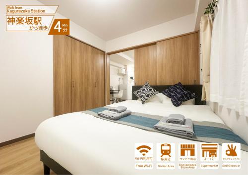 a bedroom with a large white bed with wooden cabinets at nestay apartment tokyo kagurazaka in Tokyo