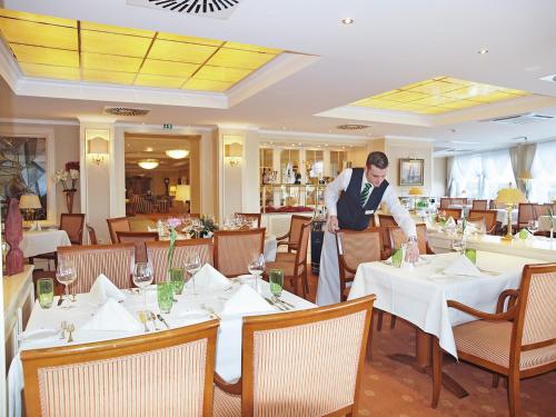 a waiter in the dining room of a restaurant at Strandhotel Duhnen in Cuxhaven