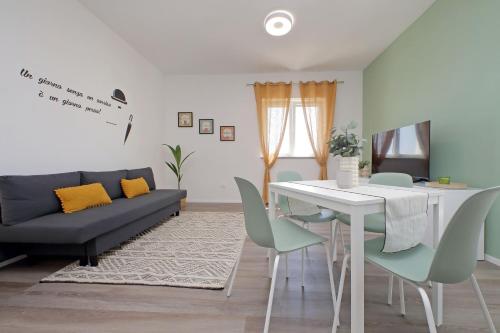 a living room with a couch and a table and chairs at Centrale & Tranquillo con Domotica - Vicino APT e Spiaggia in Fiumicino