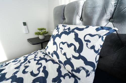 a pillow on a chair with a blue and white blanket at Amber Light Self-Check-In Apartments in Kaunas