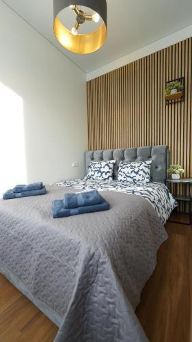 a bedroom with a large bed with blue pillows on it at Amber Light Self-Check-In Apartments in Kaunas