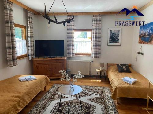 a living room with two beds and a flat screen tv at Gasthof Frasswirt in Frass