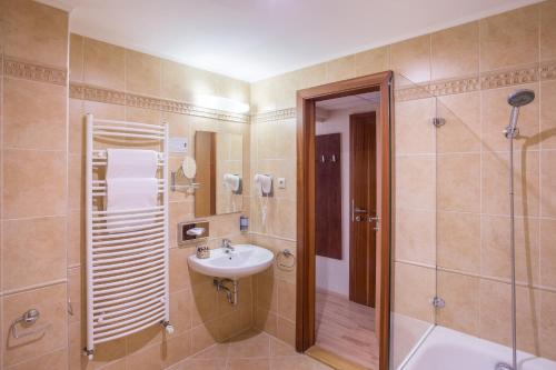 a bathroom with a sink and a shower at Holiday Beach Budapest Wellness Hotel with Sauna Park in Budapest