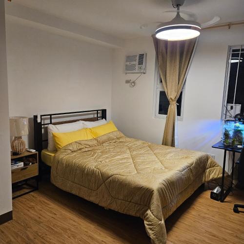 a bedroom with a bed with yellow pillows at Mench Staycation in Manila