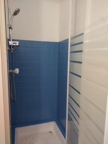 une salle de bain avec douche aux carreaux bleus dans l'établissement Appartement vue sur mer, à Soulac-sur-Mer