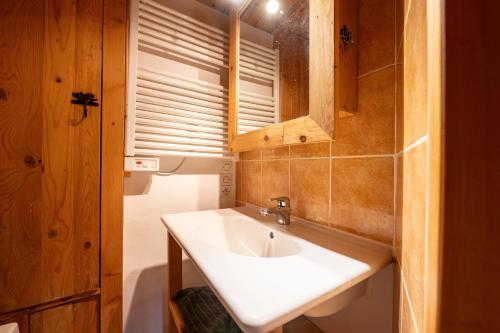 a bathroom with a white sink and a window at Chalet le Persan Courchevel 10 pl in Courchevel