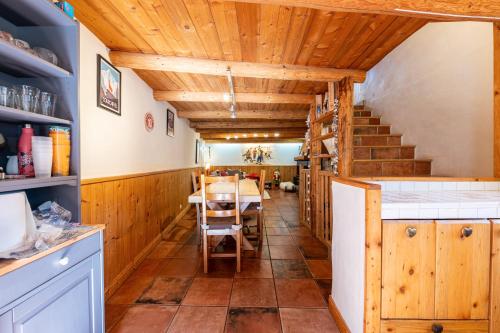 a kitchen with wooden ceilings and a table with chairs at Chalet le Persan Courchevel 10 pl in Courchevel