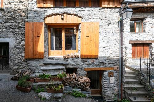 a stone building with a wooden door and a window at Chalet le Persan Courchevel 10 pl in Courchevel