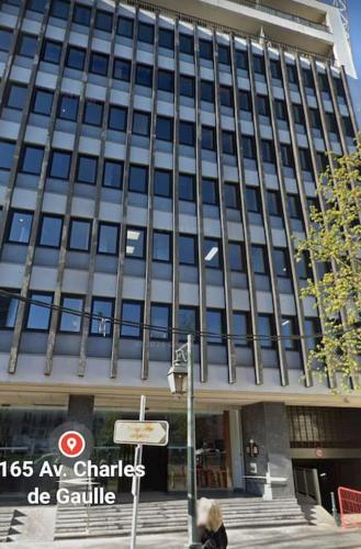 une femme marchant devant un bâtiment dans l'établissement Studio Neuilly sur Seine, à Neuilly-sur-Seine