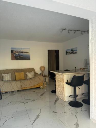 un salon avec un canapé et une table dans l'établissement Grand Studio Cabine proche plage et port, à Gruissan