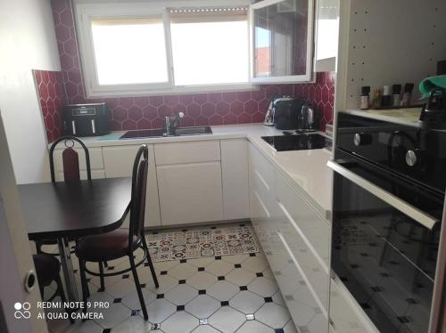 - une cuisine avec un évier, une table et une chaise dans l'établissement Grand F3 COSY proche du centre-ville, à Strasbourg