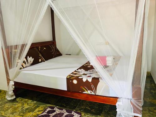 a bedroom with a bed with mosquito netting at Black Panther Yala in Tissamaharama