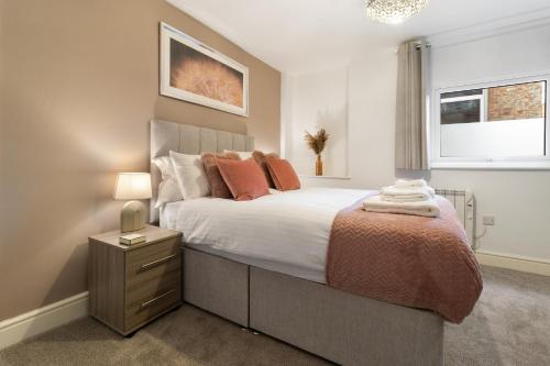 a bedroom with a large bed with orange pillows at WhiskAwayStays - Jenkins House - Apartment 1 in Worcester