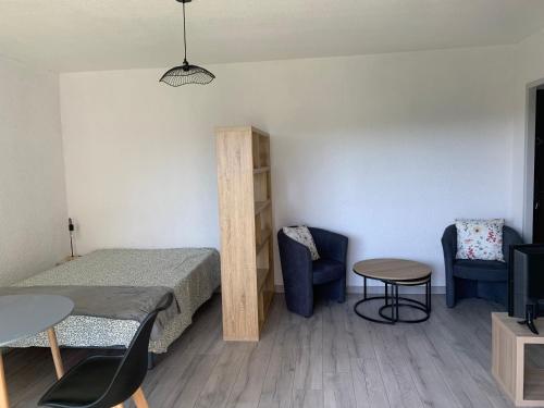 Cette chambre comprend un lit, deux chaises et une table. dans l'établissement Charmant studio au Cézanne, à Gréoux-les-Bains