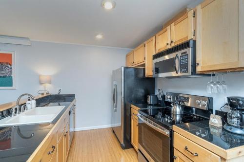 a kitchen with wooden cabinets and a stainless steel refrigerator at Comfy Casual Near Gondola & Main Street! Needle Rock 3 condo in Telluride