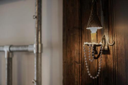 a light attached to a wooden door with beads on it at Plgfe - Maison d'hôtes EPICUROOMS - Suites romantiques 5 étoiles in Gallargues-Le-Montueux