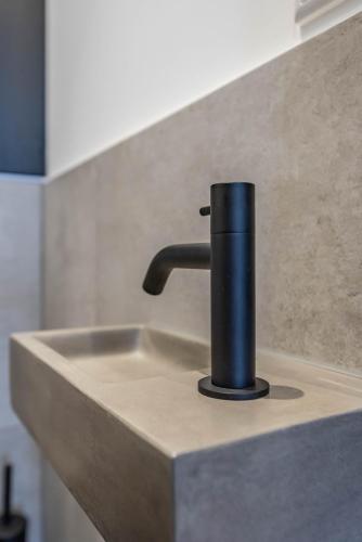 a sink with a black faucet on a counter at Luxury Watervilla Near Amsterdam And Schiphol in Aalsmeer