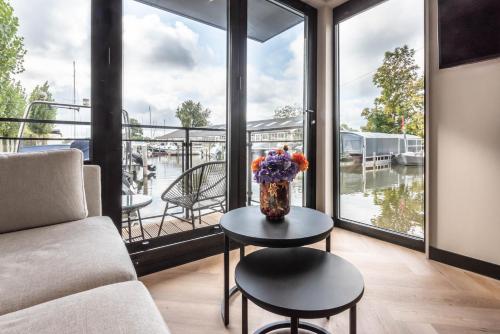 a living room with a vase of flowers on a table at Luxury Watervilla Near Amsterdam And Schiphol in Aalsmeer