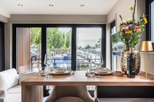 a dining room with a table with a vase of flowers at Luxury Watervilla Near Amsterdam And Schiphol in Aalsmeer