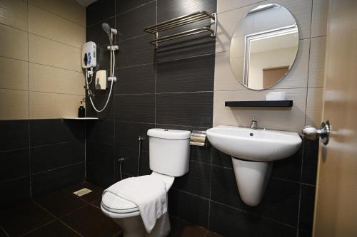 a bathroom with a toilet and a sink and a mirror at Swing & Pillows - Sunway Pyramid PJ in Petaling Jaya