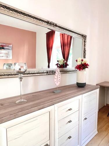 a dresser with a mirror and a wine glass at Charmanter, gemütlicher Altbau -zentrumsnah in Baden-Baden