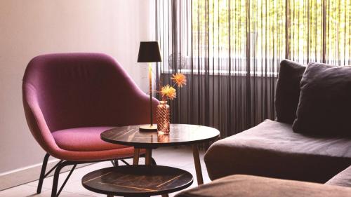 a living room with a chair and a table and a couch at City Hotel Merano in Merano