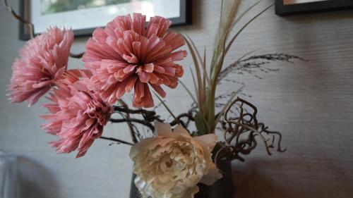 a vase filled with pink flowers on a table at City Hotel Merano in Merano