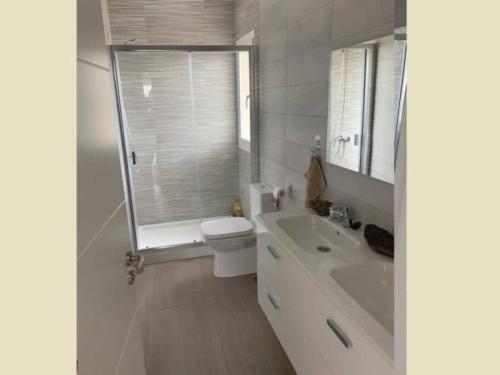 a white bathroom with a toilet and a sink at Villa di lusso con piscina e piccola spiaggia in Callao Salvaje