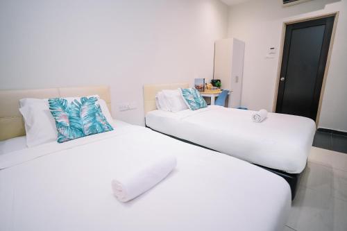 two beds in a room with white and blue pillows at Swing & Pillows - Sunway Pyramid PJ in Petaling Jaya