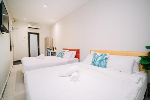 two white beds in a room with a tv at Swing & Pillows - Sunway Pyramid PJ in Petaling Jaya