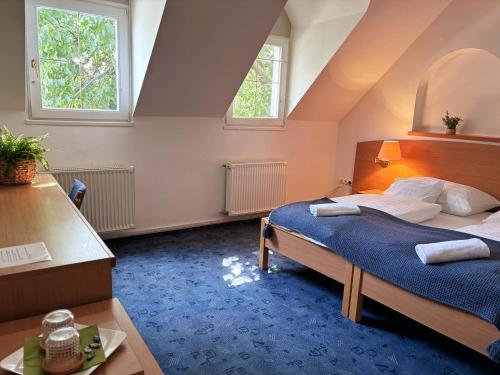 a bedroom with a bed and two windows at Levendula Resort és Rendezvényközpont in Bogács