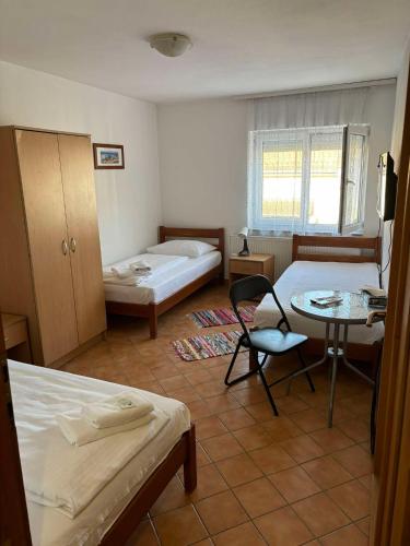 a room with two beds and a table and a desk at Vila Dora B&B in Požega