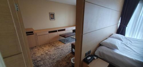 a hotel room with a bed and a desk at From H The Best Hotel Jeju Seongsan in Seogwipo