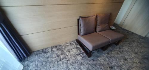 a brown chair in a room with a wall at From H The Best Hotel Jeju Seongsan in Seogwipo