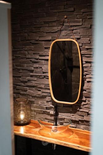 un miroir assis au-dessus d'une table en bois dans l'établissement Maison l Ônelle, à Quiévrechain