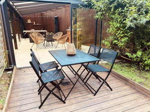 une table bleue et des chaises sur une terrasse en bois dans l'établissement Maison l Ônelle, à Quiévrechain