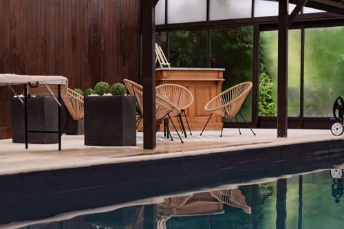 - une piscine avec des chaises et un piano à côté d'une maison dans l'établissement Maison l Ônelle, à Quiévrechain