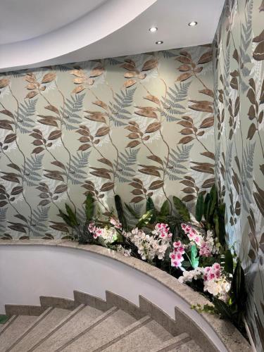 a staircase with a floral wall mural and flowers at Hotel Parma in Milan
