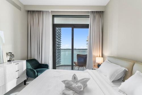 a bedroom with a white bed with a flower on it at Seaside Lux Retreat 2-BR Private Beach in Dubai
