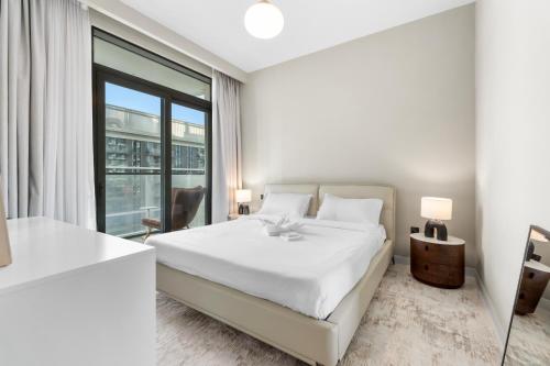 a bedroom with a white bed and a large window at Seaside Lux Retreat 2-BR Private Beach in Dubai