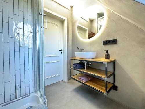 ein Badezimmer mit Waschbecken und Spiegel in der Unterkunft Stilvolles Haus mit Naturgarten & Weitblick - für Familien & Freunde in Oberschwarzach