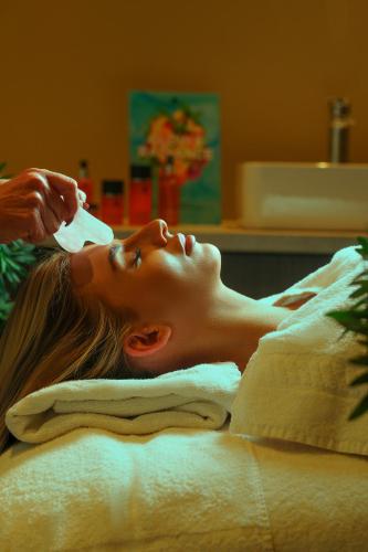 a woman laying on a bed getting her hair brushed at Park hall Hotel & Spa Lancashire, a member of Radisson Individuals in Eccleston