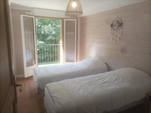 une chambre avec deux lits et une fenêtre dans l'établissement Appartement à la Montagne, à Saint-Gervais-les-Bains